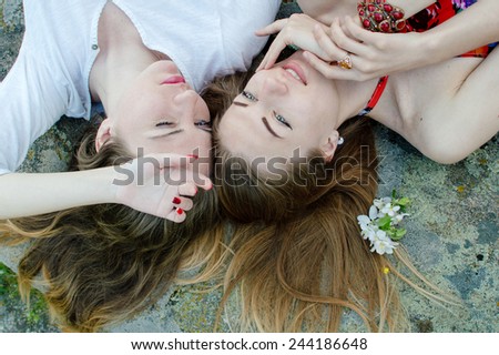 Closeup portrait of calm pretty young ladies friends relaxing on stone abstract background