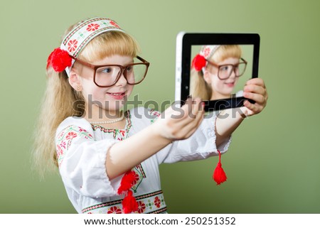 Portrait of beautiful child young lady in handmade embroidered dress and colorful wreath making self picture