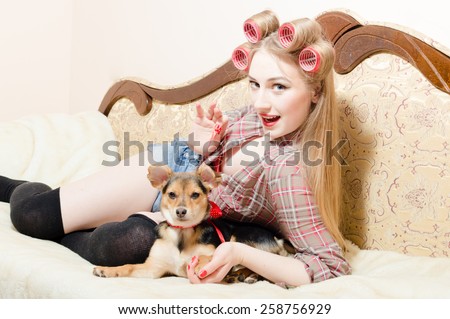 Young sexy playful woman having joyful time relaxing lying in bed with her cute dog