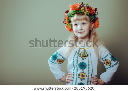 Close up of pretty little girl wearing Ukrainian handmade embroidered clothes with floral ornament