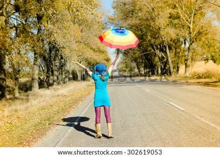Slim girl in lilac pants walking under parasol