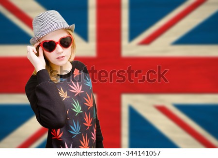 Pretty young woman in sunglasses on english union jack background
