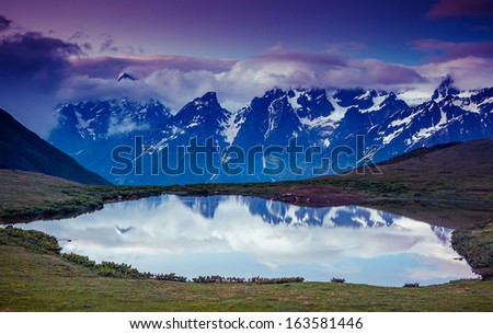 Fantastic landscape with lake Koruldi and overcast sky at the foot of  Mt. Ushba. Upper Svaneti, Mestia, Georgia, Europe. Caucasus mountains. Beauty world.