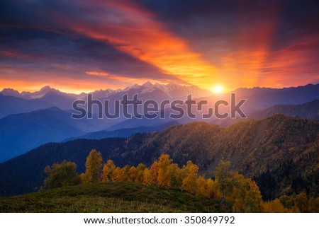 Fantastic red sunbeams with overcast sky at the foot of Mt. Ushba. Dramatic morning scene. Location Upper Svaneti, Mestia, Georgia, Europe. High Caucasus ridge. Warm toning effect. Beauty world.
