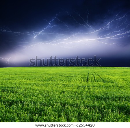 Thunderstorm with lightning in green meadow.