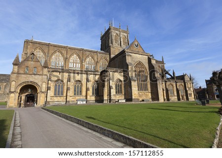 Sherborne Abbey is the Abbey Church of St Mary the Virgin in the English county of Dorset UK Blue sky behind Sherborne Abbey is the Abbey Church of St Mary the Virgin in the English county of Dorset UK Blue sky behind