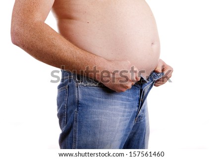 A man with a fat belly struggling to do his jeans up. White background. Concept is to lose weight and lead a healthy lifestyle.