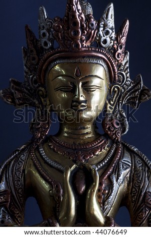Portrait of a buddha statue with black background.
