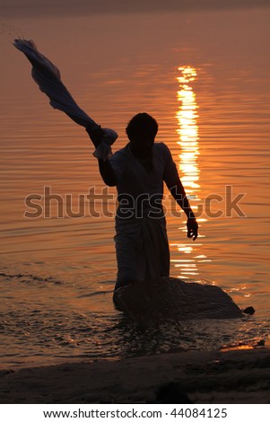 Man washing clothes in the holy ganges river.