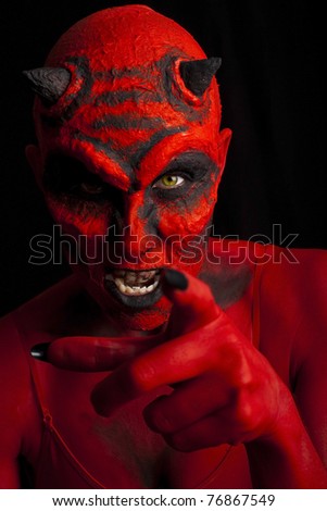 Devil woman pointing her finger. Low key lighting.