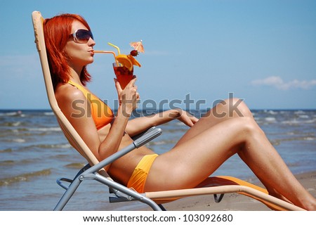 Beautiful woman with cocktail on the sea
