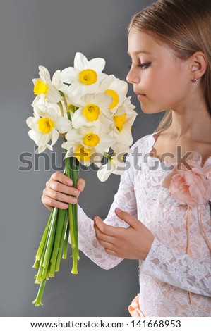 The portrait of young cute girl with narcissus
