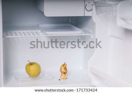One apple and	apple core  in open empty refrigerator