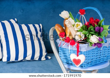 Basket with flowers and plush hearts in the blue interior