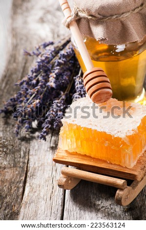 Lavender Honey in jar with honey dipper on  wooden background