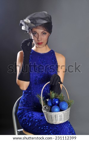 Young attractive woman in black hat and gloves with basket of balls