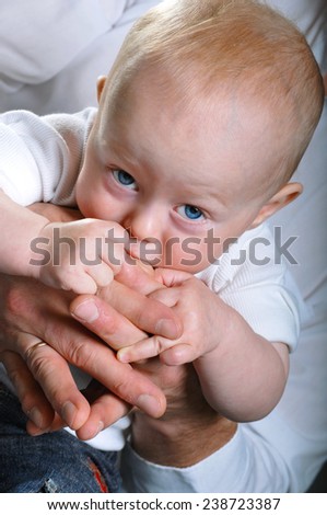 child pulls hands in his mouth