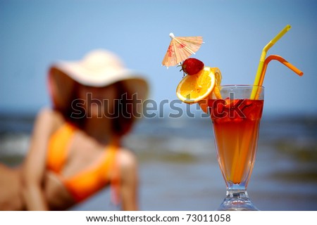 Beautiful woman with cocktail on the beach