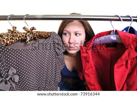 Difficult choice. The young woman chooses clothes in a case