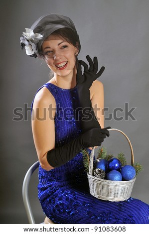 Young attractive woman in black hat  and gloves with basket of balls