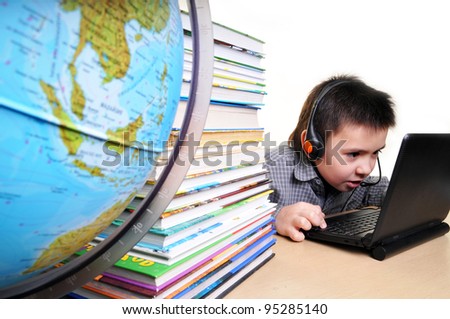 a boy in the earphones works on the computer instead of reading books