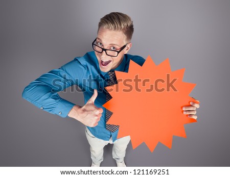 Awesome offer: Joyful salesman giving thumbs up for blank panel with space for text promoting sales isolated on grey background.