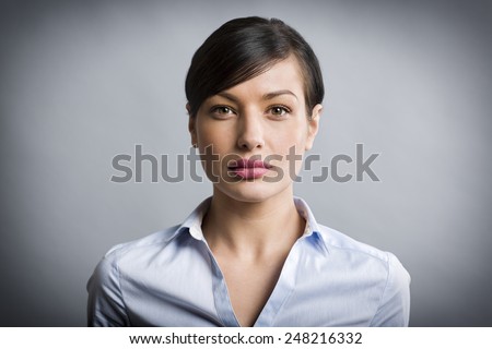Close up portrait of serious, confident businesswoman looking straight, isolated on grey background.