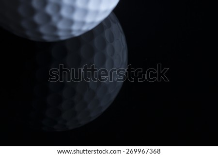 Close up of golf ball with reflection isolated on black background, copy space for text.