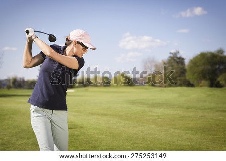 Close up of woman golf player swinging golf club, with empty copyspace.