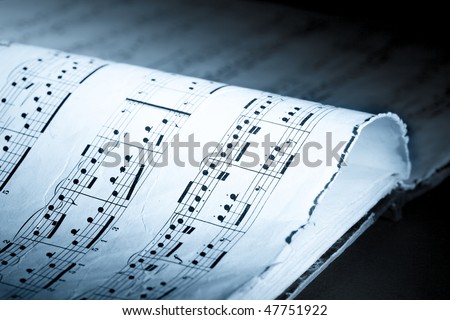 Closeup of old and torn music book, blue-toned