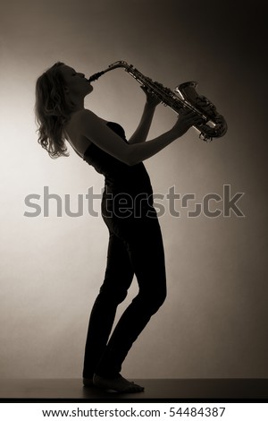 Low-light full body portrait of pretty woman playing saxophone with head back, backlit, sepia toned.