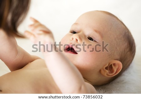 stock photo Naked sweet caucasian baby boy lying on floor and reaching out 