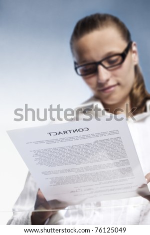 Smiling businesswoman signing a legal document or contract, view from below, blank background.