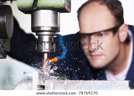 Close up of worker with safety glasses at milling machine in workshop. Close up of worker with safety glasses at milling machine in workshop.