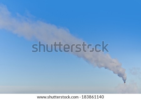 Industrial smoke stack at a power plant on a background of clear sky day