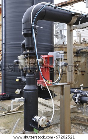 Industrial black plastic tank and control system with some branches and pumps