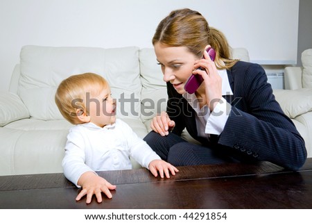 young businesswoman  talking on cell phone with her baby daughter