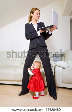Young businesswoman working with laptop and her baby daughter crying