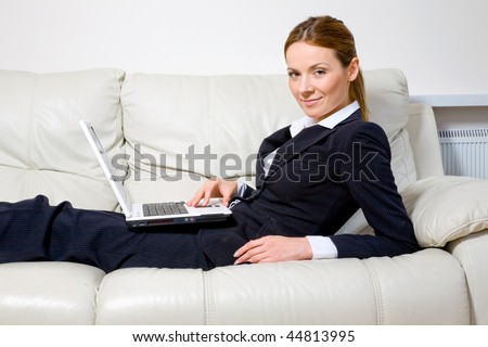 Young successful businesswoman on the couch with  laptop
