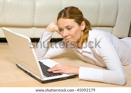 Young attractive woman laying on the floor with  laptop