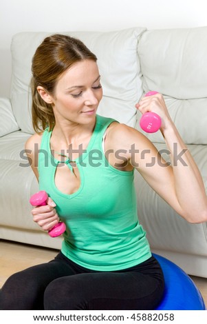 Young attractive woman exercising with dumbbells