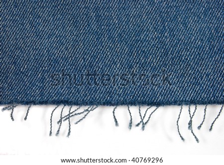 Edge of blue jeans fabric with fringe on white