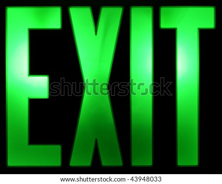 A green illuminated Exit sign isolated on a black background.