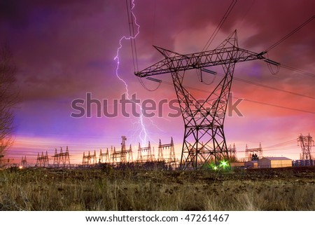 Dramatic Image of Power Distribution Station with Lightning Striking Electricity Towers.