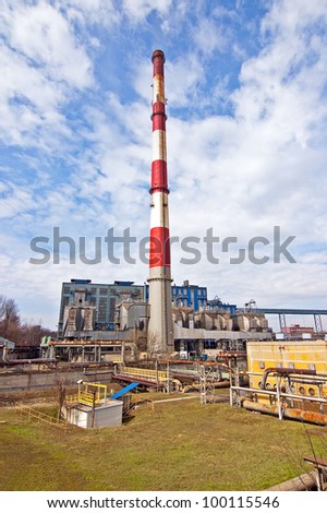 With a smoking chimney power plant on a sunny day