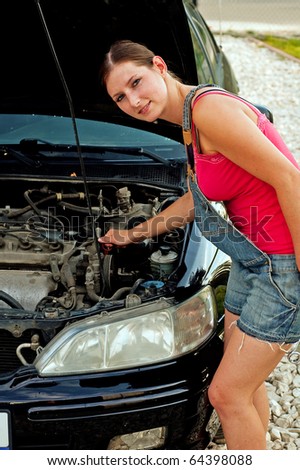 Young woman repairing her car