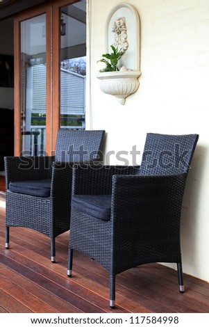 gray and black rattan tub chairs on deck