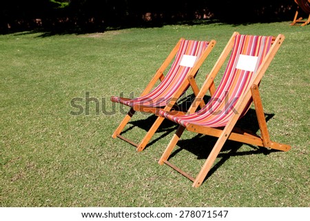 Relaxing garden chairs in garden setting surrounded by grass