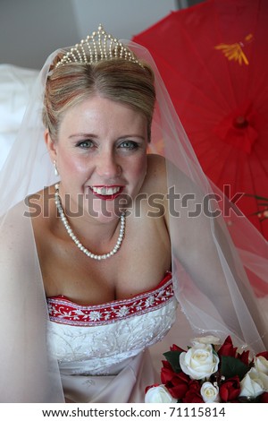 stock photo Bride and red and white wedding dress looking at camera with 