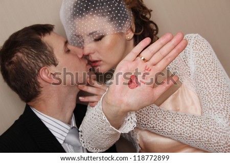 Bride and groom kissing and the hand drawn heart and says \